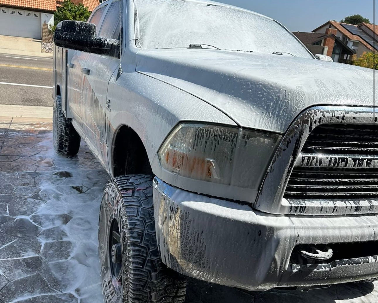 Silver pickup truck with soap suds on a driveway